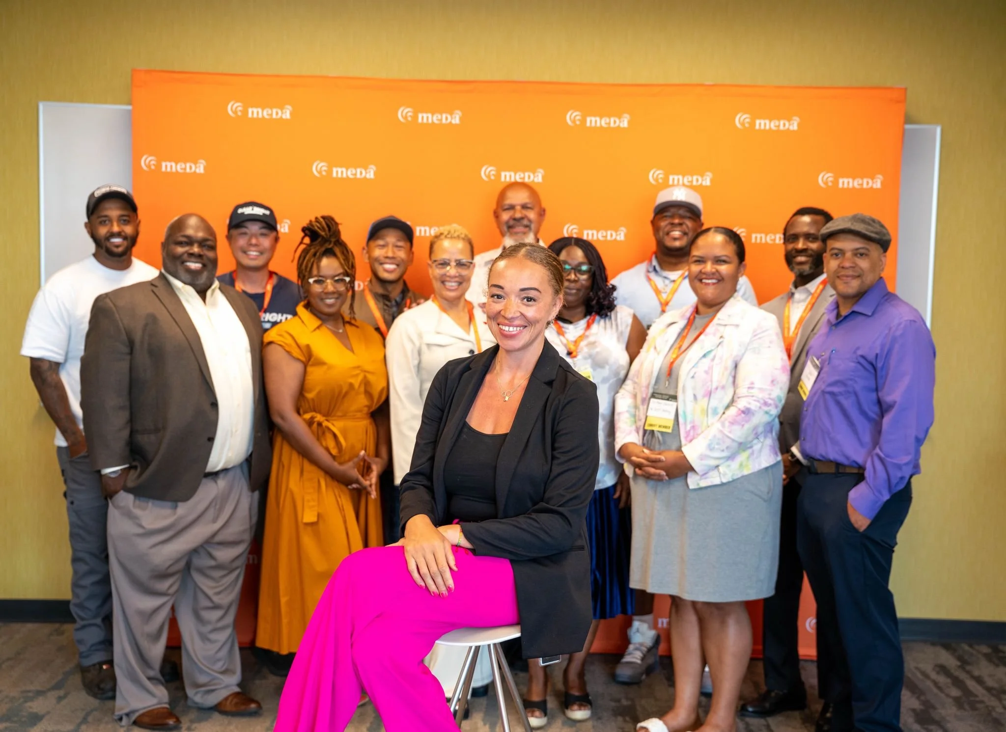 Alivia Boddie seated in front of the MEDA Volunteer Accelerator Network mentor team at a MEDA event