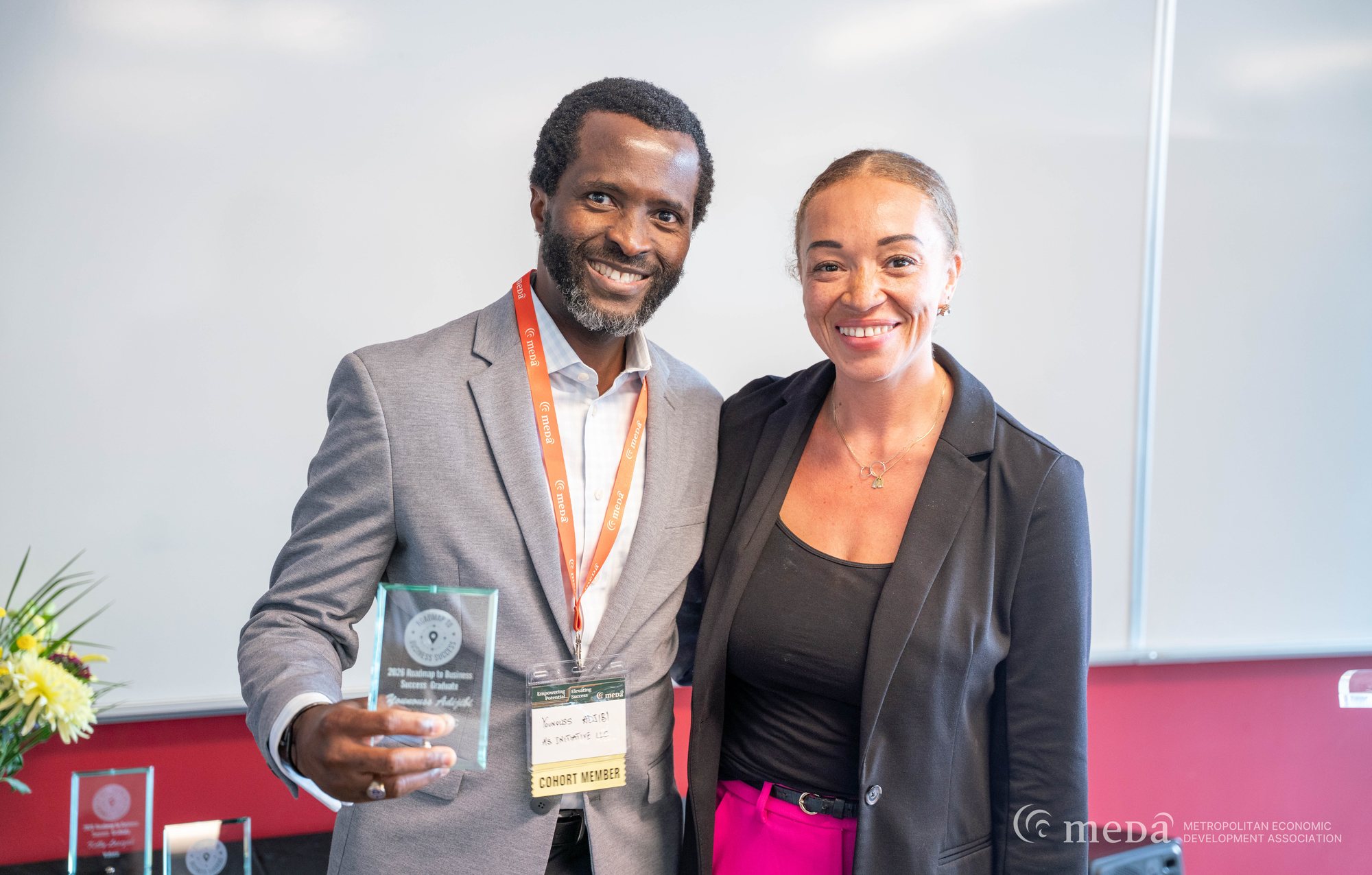 Alivia Boddie standing with a Roadmap to Business Success graduate at an awards event